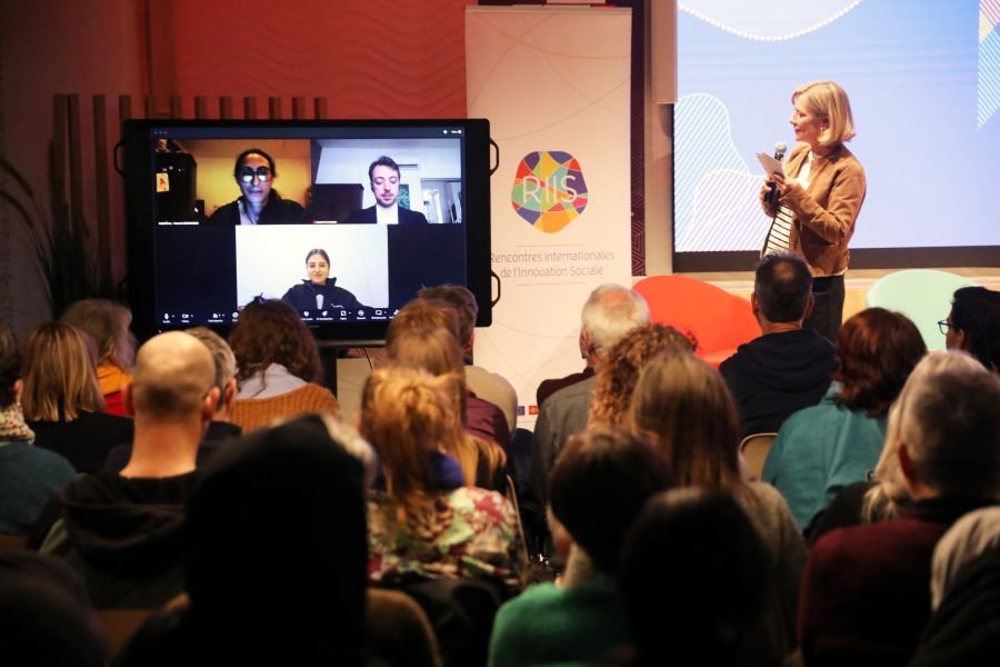 Photo de la scène et de l'écran avec les personnes intervenant à distance